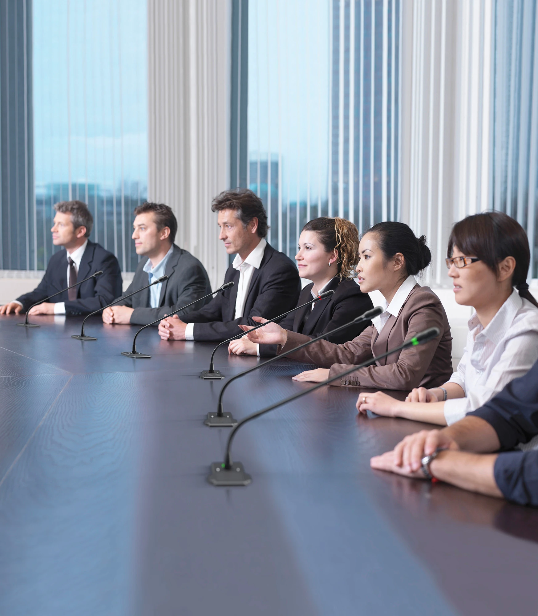 Bosch DICENTIS Flush conference microphones built into a meeting room table with delegates seated